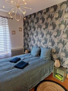 1 dormitorio con cama con sábanas azules y techo en Appartement Montceau-Les-Mines, en Montceau-les-Mines