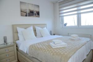 um quarto branco com uma cama com toalhas em Irina Lux Apartment em Negotin