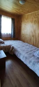 a large bed in a room with a window at Cabaña dalcahue in Dalcahue