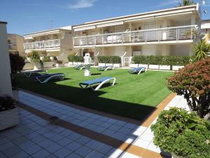 un edificio de apartamentos con un patio verde con bancos en Apartamento en Vinaros, en Vinarós