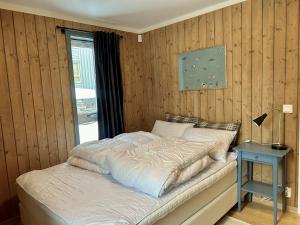 a bed in a bedroom with a wooden wall at Mailatunet - Vestlia resort in Geilo