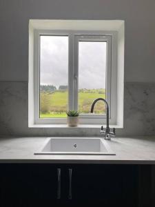 um lavatório de cozinha em frente a uma janela em Delightful Artistic Granite Barn in Rural Hamlet em Launceston