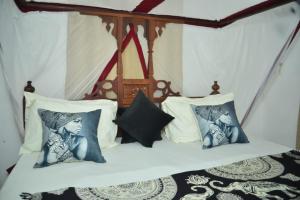 a bedroom with a bed with two pictures on it at La Neisha Hotel Zanzibar in Stone Town