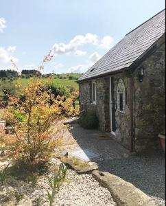 a stone building with a pathway next to a garden at Delightful Artistic Granite Barn in Rural Hamlet in Launceston