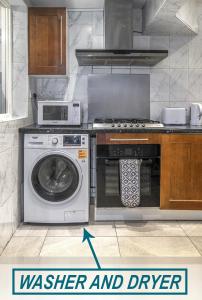 a kitchen with a washing machine and a microwave at 1 bedroom flat with 3 beds,Luton Town and station F3 53 in Luton