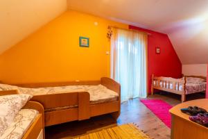 1 dormitorio con 2 camas y pared amarilla en Vila Kristina, en Andrijevica