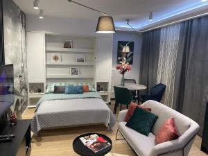 um quarto com uma cama, uma mesa e cadeiras em New comfortable apartment with balcony and sauna on Klimieckiego street na Cracóvia