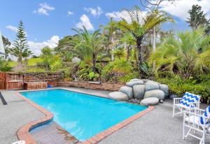 a swimming pool in a yard with a patio at Secluded, private rural retreat mins from Warkworth -"Avondale" Minihouse in Warkworth