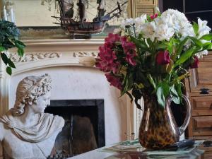 a vase of flowers on a table next to a fireplace at Flawsome stays Unique Edwardian Home near the Harbour and town perfect for Families up to 8 guests in Ramsgate