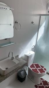 a bathroom with a toilet and a sink and a shower at RB hospedagem in Cabo Frio