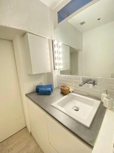cocina blanca con lavabo y espejo en Lovely flat in the heart of the Navigli, en Milán