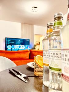 a bottle of alcohol sitting on a table with a plate at Rooms Near Me - Apartment 3, Smart Tv, Free Parking in Halesowen
