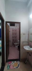 a bathroom with a door open to a bathroom with two sinks at IK Homestay in Varanasi