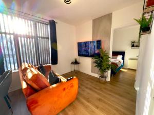 a living room with a couch and a tv at Rooms Near Me - Apartment 3, Smart Tv, Free Parking in Halesowen