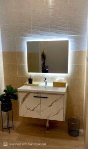 a bathroom with a sink and a mirror at استديو بأثاث انيق -النقرة in Hail