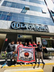 un grupo de personas sosteniendo una pancarta delante de un edificio en LA CASONA DE YANAHUANCA, en Yanahuanca