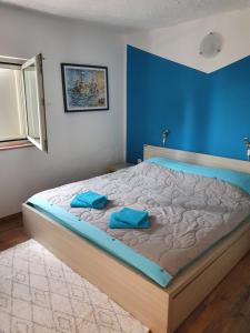 a bedroom with a bed with two blue pillows on it at Heavenly House by the sea in Savudrija