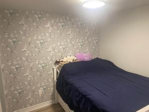 sypialnia z łóżkiem i ścianą z kwiatami w obiekcie Specious 2 Bedroom Condo in Collingwood w mieście Collingwood