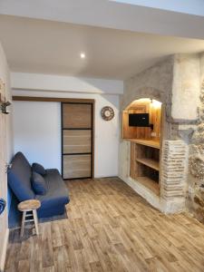 een woonkamer met een blauwe bank en een open haard bij Le meublé de Jules et Jade in Casteljaloux