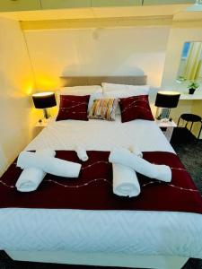 sypialnia z dużym łóżkiem z białymi i czerwonymi poduszkami w obiekcie Glamorous Palace with spa bath w mieście North Shields