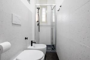 a white bathroom with a toilet and a shower at A.P. Appartamento o camera in Corsico