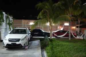 a white car and a black car parked in a driveway at La Arteza Pacasmayo in Pacasmayo