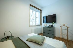 Schlafzimmer mit einem Bett und einem Flachbild-TV in der Unterkunft WIDOK przy Jeziorze Zegrzyńskim in Zegrze