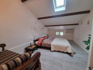 een slaapkamer op zolder met een bed en een raam bij Jolie Villa piscine à 15 min du Barcarès in Salses-le-Chateau