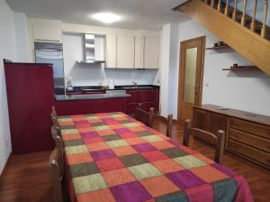 una cocina con una mesa con una manta de colores. en Dúplex Parque Europa II, en Ezcaray