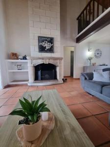 een woonkamer met een bank en een open haard bij Jolie Villa piscine à 15 min du Barcarès in Salses-le-Chateau
