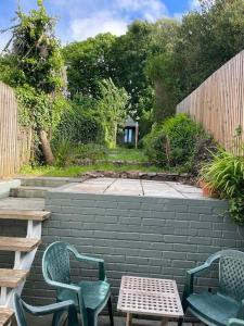a patio with two chairs and a table and chairs at Tewyn Cottage - Charming 2 bed getaway in the SW! in Hayle