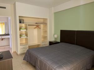 a bedroom with a bed and open shelves at Los Robles Apart Hotel l Suites & Spa in Sierra de la Ventana +124 photos