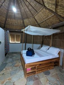 a bed in a straw hut with a bag on it at REFUGE du MONT AGOU 