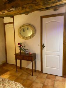 een kamer met een deur en een tafel met een klok bij LA FERME JARLAN in Berganty