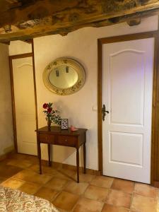 a room with a door and a table with a clock at LA FERME JARLAN in Berganty