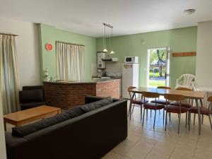 a living room with a couch and a table at Los Robles Apart Hotel l Suites & Spa in Sierra de la Ventana