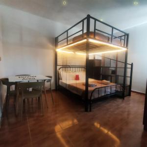 een kamer met een stapelbed en een tafel met een tafelblad bij Jessica Flat GuestHouse , Holiday and Business in Cospicua