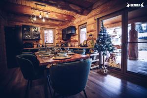 a kitchen with a table with chairs and a christmas tree at Bratnia Bystre in Bystre