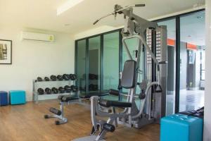 un gimnasio con cinta de correr, silla y pesas en 中央公寓 1bedroom Centrio Condominium, en Ban Rangeng