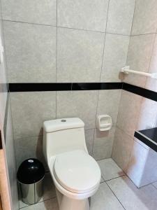 La salle de bains est pourvue de toilettes blanches et d'une poubelle. dans l'établissement LA CASONA DE YANAHUANCA, à Yanahuanca