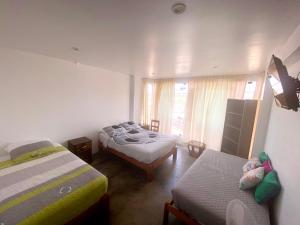 1 dormitorio con 2 camas y ventana en Killamoon House Paracas, en Paracas