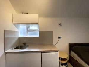a small kitchen with a sink and a bed at Modern Brand New Build STUDIO Apartments LONDON in London