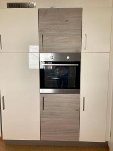 Komforthaus Gartenfreude في ساشسينهايم: مطبخ فيه دواليب بيضاء وفرن