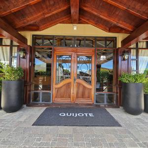 - une entrée pour un bâtiment avec une porte en bois dans l'établissement Hotel Quijote, à El Calafate