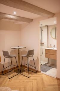 La salle de bains est pourvue d'une table, de 2 chaises et d'une douche. dans l'établissement Petit studio pour 2 personnes au cœur de Selestat, à Sélestat