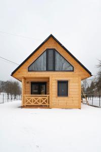 een klein houten gebouw met een raam in de sneeuw bij Pod Kalwarią 