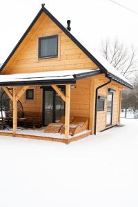 eine Blockhütte mit Schnee auf dem Dach in der Unterkunft Pod Kalwarią 