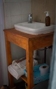 - Baño con lavabo y toallas en una mesa en Uy MÁGICA Cabaña en entorno Natural único, en Mercedes