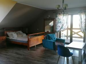 a bedroom with a bed and a chair and a table at Izerska Zagroda in Świeradów-Zdrój