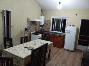 uma cozinha com uma mesa e um frigorífico branco em Cabañas Raíces de la Estancia 2 em El Amparo